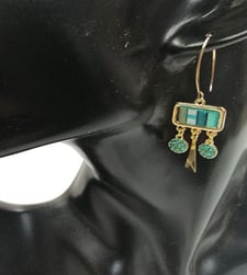 a pair of earrings with turquoise and gold earrings