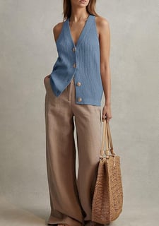 a woman in a blue cardigan vest and pants