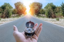 a person holding a compass on a road