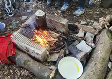 a group of people sitting around a camp fire 