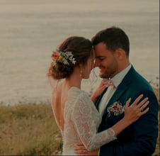 Moment complice des mariés enlacés au bord de la mer, capté par une vidéaste de mariage