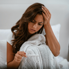 a woman in a white sweater and a white sweater feeling fever