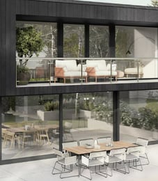 a modern house with a balcony and a table with chairs