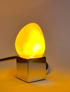 a yellow light bulb sitting on top of a table