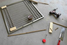 image showing cage door frame with cardboard paper and power drill tool and wood in development