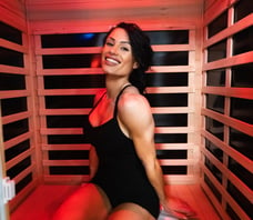 woman in a black swimsuit sitting in a infrared sauna ms bikini olympia international jennifer dorie