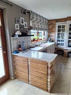 Cuisine avant transformtion avec plans de travail en carrelage et murs en briques