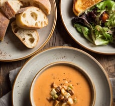 a table with two plates of soup and bread