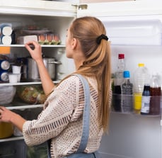 a woman standing and uninstalling the refrigerator