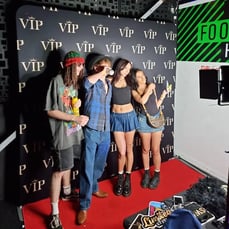 4 people posing in front of a VIP backdrop in the digital photo booth in Brisbane.