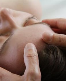 een vrouw krijgt een manuele behandeling aan haar hoofd