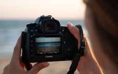 a person holding a camera and taking a picture of a camera