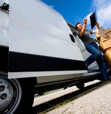 a man standing next to a van with boxes on it