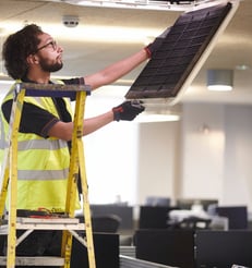 Técnico realizando mantenimiento de aire acondicionado en oficina de Valencia