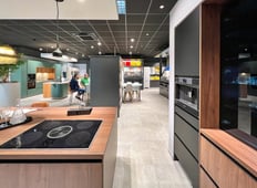 Détail d'une cuisine haut de gamme exposée dans un showroom à Hyères, avec appareils encastrés et finitions en bois