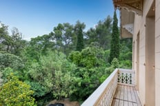 Balcon d'une maison de maître, entouré de verdure dans un terrain boisé, capturé par un photographe immobilier à Toulon.