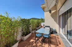 Photographie d’une terrasse ensoleillée avec vue sur le jardin d’une maison à Cuers.