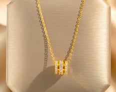 a necklace with a diamond and a gold necklace