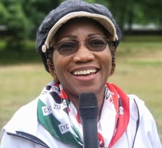 a woman in a hat and NDC scarf around her neck