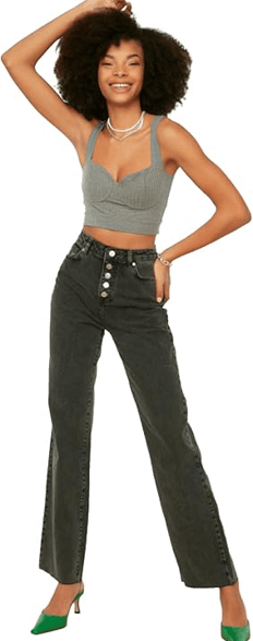 femme en jean debout bras sur la tete