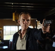 a man holding a gun in a room