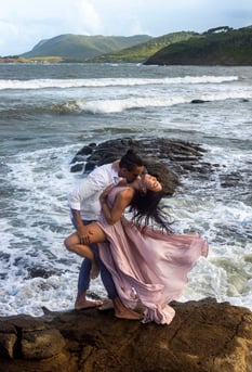 a man and woman kissing on a rock