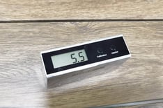 Brightness meter on an antique-finished solid wood table, indicating precise luminosity control for 