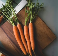 carrots and a knife on a wooden board