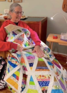 Cheryl Miller finishing a quilt for donation; photo by Lucy Lester