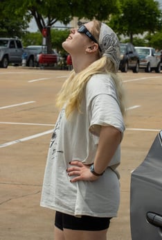 Abigail Bolton, 19, stand in the 85C Bakery Cafe parking lot to watch the solar eclipse. Photo by Taylor Pleasant