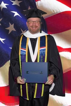 Andrew in full regalia after graduating with his Master's in Military and Trauma Psychology