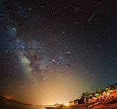 um céu noturno com estrelas e uma estrela cadente