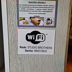Aviso de wifi e lanchonete na parede do Studio Brothers em Porto Alegre