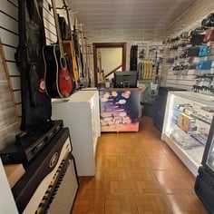 Interior da loja de instrumentos do Studio Brothers em Porto Alegre com guitarras e amplificador