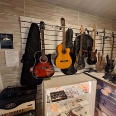 Guitarras penduradas e vitrine de acessórios na loja do Studio Brothers em Porto Alegre