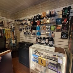 Parede com cordas pedais e acessórios musicais na loja do Studio Brothers em Porto Alegre