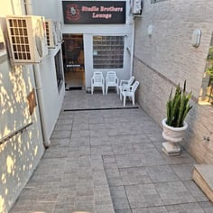 Entrada do lounge do Studio Brothers com pátio e cadeiras em Porto Alegre
