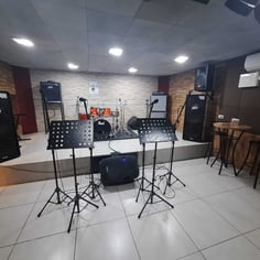 Palco com bateria amplificadores e estantes de partitura no Studio Brothers em Porto Alegre