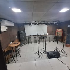 Sala de ensaio com palco iluminação e microfones no Studio Brothers em Porto Alegre