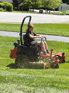 a man riding on a lawn mower with a lawn mower