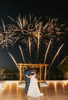 Golden fireworks lighting up a Santorini evening wedding reception.