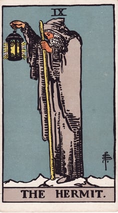 uma carta de tarô mostrando o eremita de capuz segurando uma lanterna