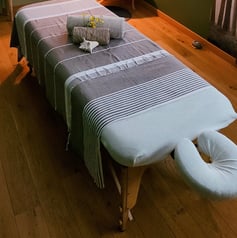 Présentation de la table de massage avec le linge pour le soin au cabinet de massage