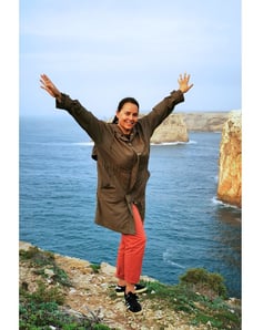 a woman standing on a cliff overlooking the ocean