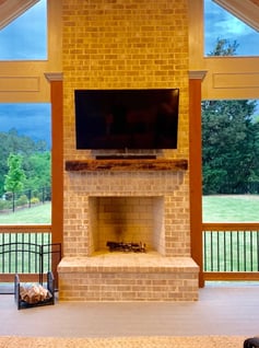 outdoor tv mounted over a brick fireplace