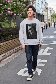 a man in a sweatshirt and jeans walking down a street