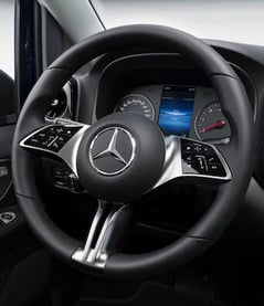Volant d’un Mercedes Vito noir en location, avec tableau de bord visible en arrière-plan