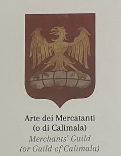 a medieval guild emblem with an eagle on a bale of cloth
