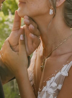 une main d'homme qui caressse le visage d'une mariée