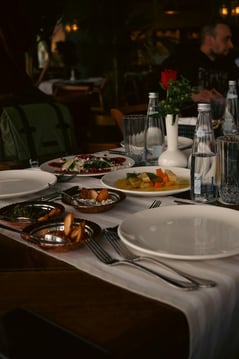 a table with plates of food and glasses